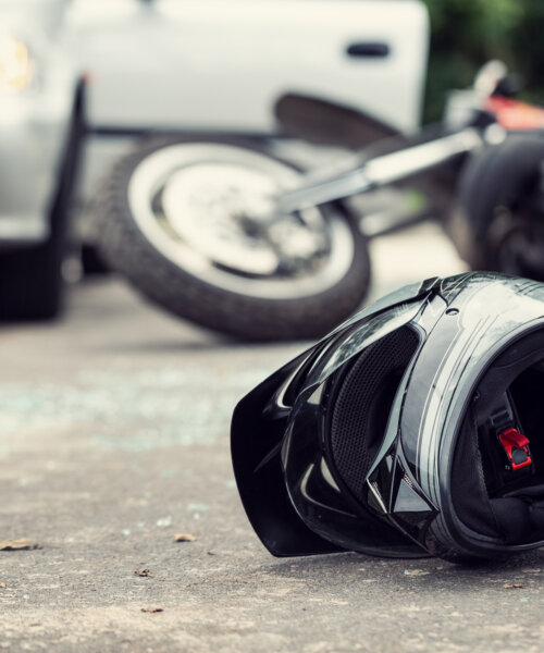 Close-up of a helmet of a driver with a blurred motorbike and car in the background