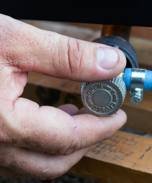 man's hand opens or closes gas valve on gas pipe, closeup