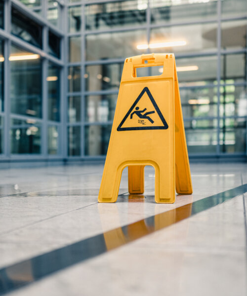 Yellow sign on floor that alerts for wet floor.