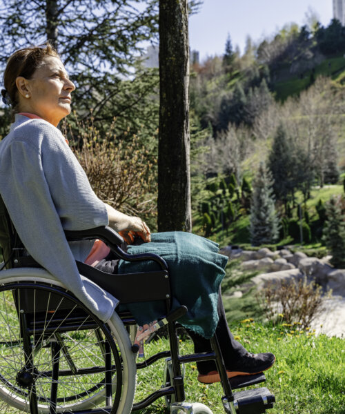 Pensive disabled senior grandma sit on wheelchair