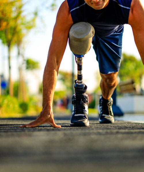 disabled athlete man with prosthetic leg starting to run at the beach on a treadmill outdoors at sunset.