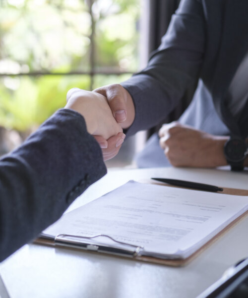 Cropped imaged of male lawyer shaking hands with client. Legal services, advice, justice and law concept.