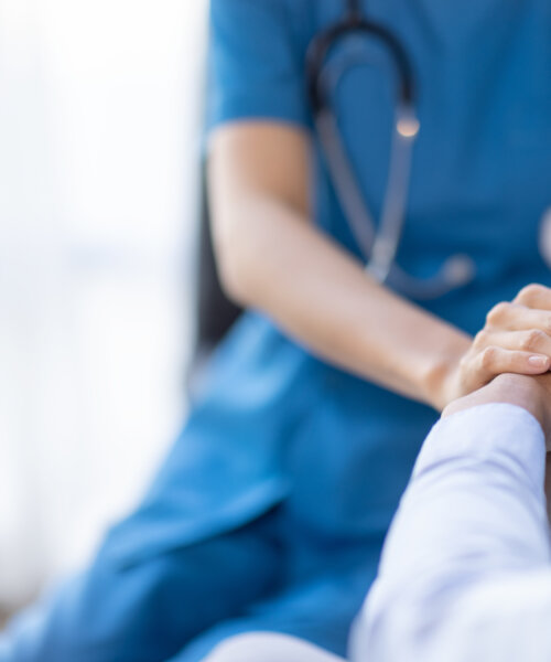 Cropped shot of a female nurse hold her senior patient's hand. Giving Support. Doctor helping old patient with Alzheimer's disease. Female carer holding hands of senior man