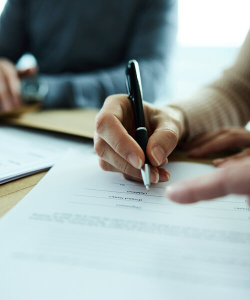 Close up of unrecognizable woman signing a contract in the office.