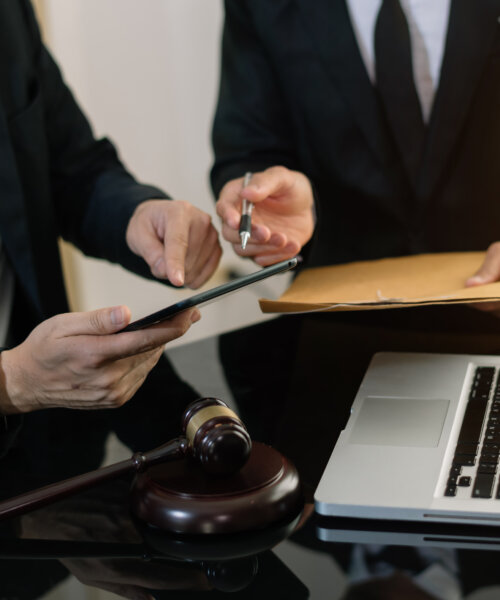 Business and lawyers discussing contract papers with brass scale on desk in office. Law, legal services, advice, justice and law concept .