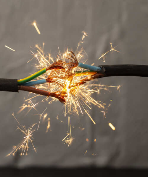 sparks explosion between electrical cables, fire hazard concept, soft focus close up