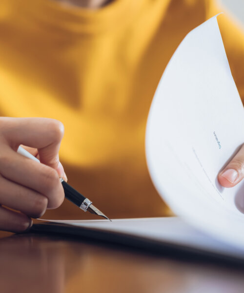 Woman signing document and hand holding pen putting signature at paper, order to authorize their rights.