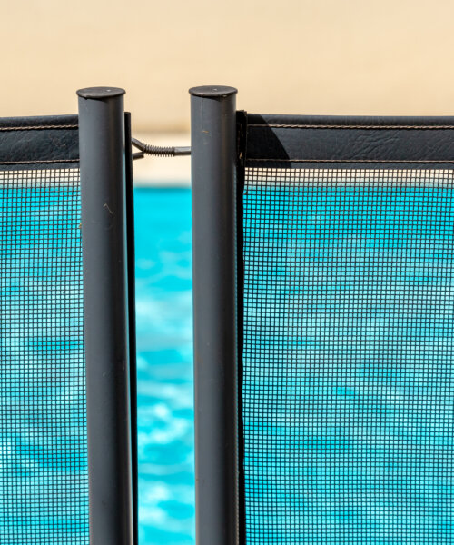 View of a pool through a mandatory safety net on the edges of a private pool