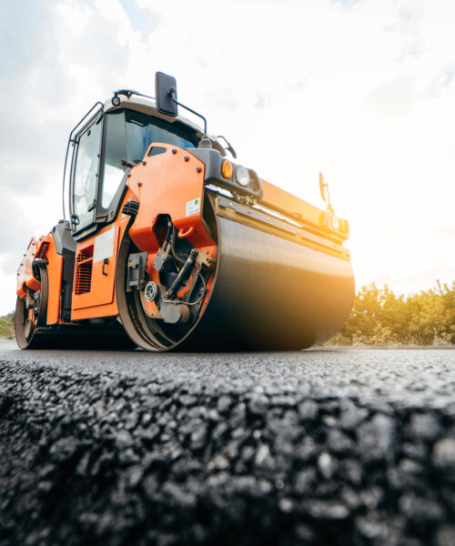 Vibratory asphalt roller compactor compacting new asphalt pavement. Road service repairs the highway