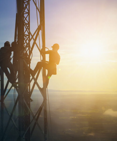 Silhouette electrician work on high ground heavy industry concept. Construction of the extension of high voltage in high voltage stations safely and systematically over blurred natural background.