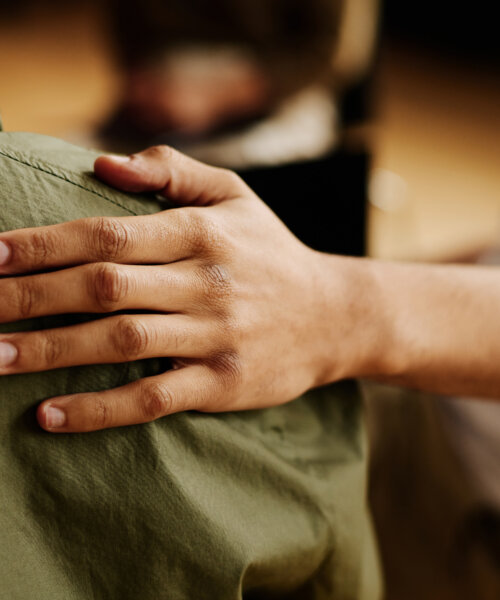 Hand of young supportive man consoling his friend or one of attendants with post traumatic syndrome caused by dramatic life event