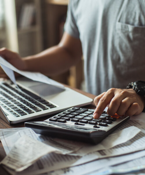 Men is calculating the cost of the bill. pressing the calculator.