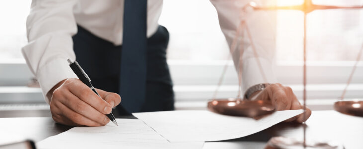 Lawyer leaning over a desk reviewing documents