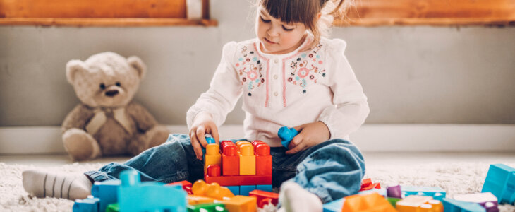 Sweet child playing with plastic blocks