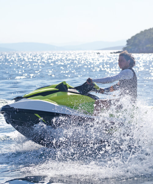Man drives orange jet ski on turquoise sea on a blue day