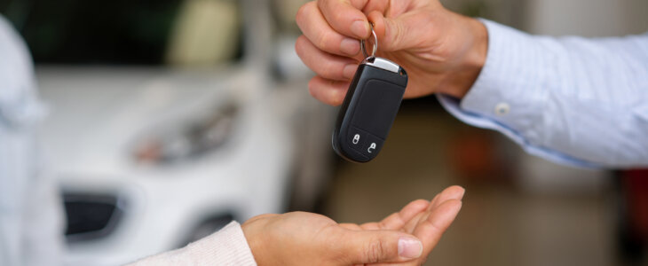 Close-up on a salesman giving the keys to their new car