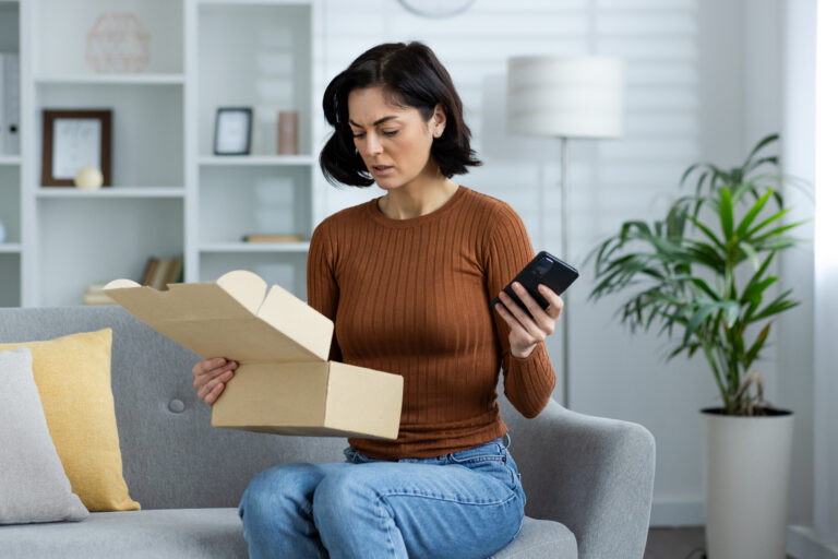 An upset young woman opening a incorrect package