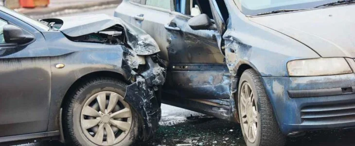 Two cars involved in a collision, with one car’s front end crashed into the side of another vehicle.