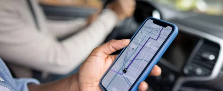 Passenger using rideshare app on smartphone while in a car.