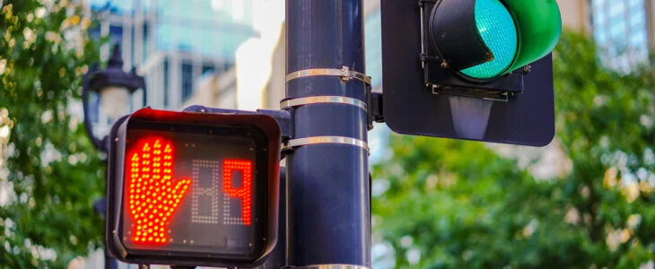 Close-up of a traffic light with a green signal for vehicles and a 