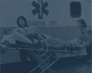 Paramedics transporting a patient on a stretcher into an ambulance