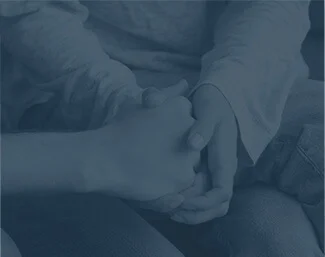 Two people holding hands in a gesture of comfort and support