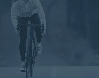 Cyclist riding a road bike on an open road, wearing athletic gear