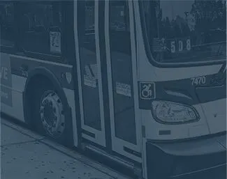 Public transit bus with doors open at a stop, accessibility signs visible