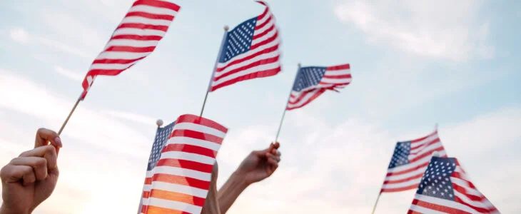 People's hands holding miniature American flags
