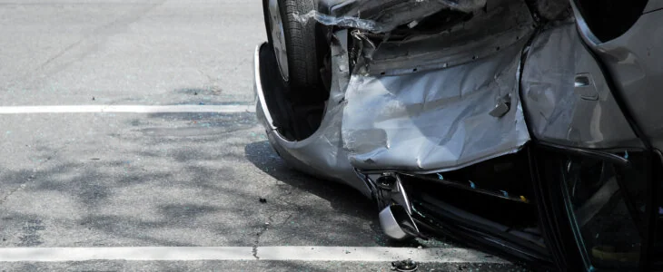 Damaged car flipped on its side after a serious road accident
