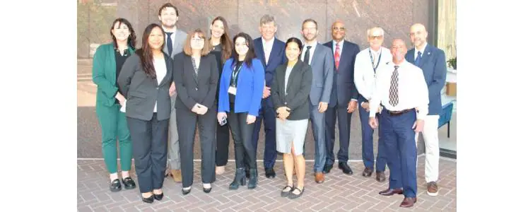 Group of professionals posing together for a team photo outdoors
